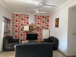 a living room with two chairs and a television at SPLENDID APARTMENTs in Mbarra Kunku