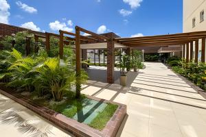a courtyard with plants and a building at Apto 2/4 com AR a 7min da Praia de Aruana in Santa Maria
