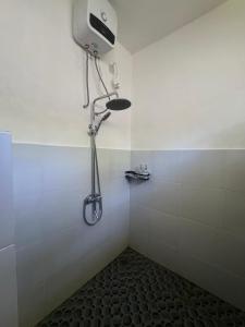 a shower in a bathroom with a shower head on the wall at Rinjani Koceng Bungalows in Tetebatu