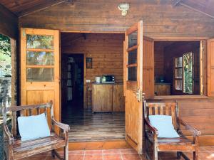 two chairs sitting on the porch of a cabin at Cottage 50 m from the beach in Blue Bay