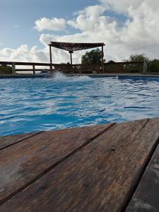 a swimming pool with a wooden deck and a gazebo at Casa para 5 personas in Juan L. Lacaze