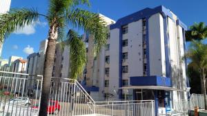 ブラジリアにあるAconchegante proxima ao parque e ao setor hospitalarの建物前のヤシの木