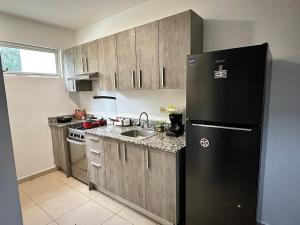 Las LajasにあるHouse equipped with 2 bedrooms and 3 poolsの黒い冷蔵庫とシンクのあるキッチン