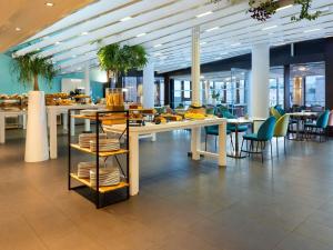 a cafeteria with tables and chairs with food on them at Novotel Marseille Vieux Port in Marseille