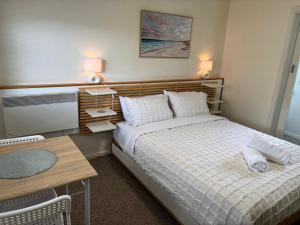 ein kleines Schlafzimmer mit einem Bett und einem Tisch in der Unterkunft Stonez Boutique Accommodation in Clunes