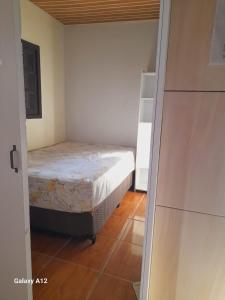 a small bedroom with a bed and a closet at Apartamento com 2 quartos suítes em Tramandaí in Tramandaí