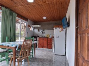 a kitchen with a table and a refrigerator at Departamentos Don Carlos in Villa Cura Brochero