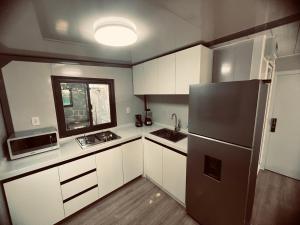 a kitchen with white cabinets and a stainless steel refrigerator at We Home Ajijic in Ajijic