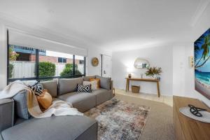 a living room with a couch and a large window at Beach Holiday Villa Jervis Bay in Vincentia