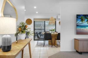 a living room with a table and a dining room at Beach Holiday Villa Jervis Bay in Vincentia
