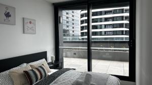 ボックスヒルにあるWhitehorse SkyHomeのベッドと大きな窓のある寝室 +21枚の写真