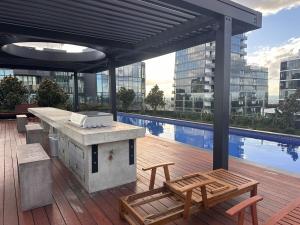 ボックスヒルにあるWhitehorse SkyHomeのプールのある建物にあるグリル付きのパティオ