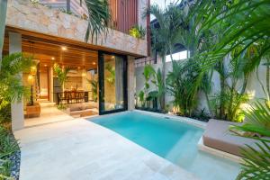an indoor swimming pool in the backyard of a house at Blacksand Villas Bingin, Uluwatu by Sandara in Uluwatu