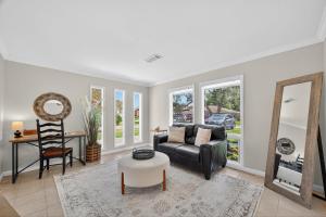 a living room with a couch and a mirror at Spacious Family Home BBQ and Outdoor Area in Shoreacres
