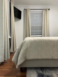 a bedroom with a bed and a window with curtains at Hibiscus Retreat - Queen non smoking guest unit in Fayetteville