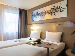 a hotel room with a bed with a table at ibis Styles Paris Bercy in Paris +76 photos