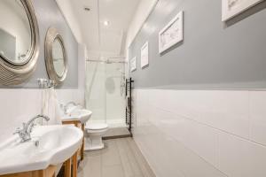 a white bathroom with two sinks and a toilet at Old Cottage The Log Cabin in Bacton +33 photos