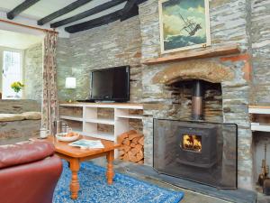 a living room with a stone wall with a fireplace at 3 Bed in Boscastle 75145 in Boscastle