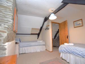 a room with two beds and a door to a bedroom at 3 Bed in Boscastle 75145 in Boscastle