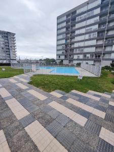 a pool in front of a large building at Acogedor departamento sector Puertas del Mar in La Serena