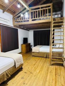 een slaapkamer met twee stapelbedden en een flatscreen-tv bij Casa de Diamantes in Tela