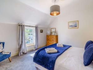 a bedroom with a blue bed and a window at 2 Bed in Glenridding 85425 in Glenridding