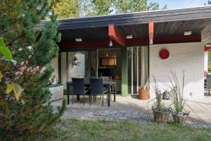 eine abgeschirmte Terrasse mit einem Tisch und Stühlen in der Unterkunft Cozy Cottage On Natural Plot in Gudmindrup + 17 Fotos