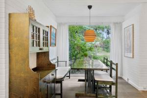 ein Esszimmer mit einem Tisch und einem Fenster in der Unterkunft Cozy Cottage On Natural Plot in Gudmindrup