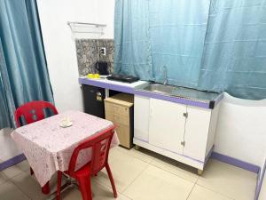 a small kitchen with a table and a sink at Faith Accommodation in Apia
