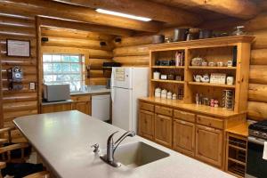a kitchen with wooden walls and a white refrigerator at Vienna Villa - 3 Bed 3 Bath Vacation home in Shaver Lake in Shaver Lake