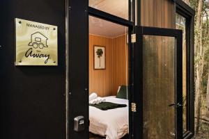 a room with a bed and a sign that reads university at Van Demears Escapes by Tiny Away in Tamborine