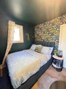 a bedroom with a bed with a floral accent wall at Dream room in Moncton