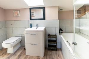 a bathroom with a sink and a toilet and a shower at No.3 Long Barn in Wangford +19 photos