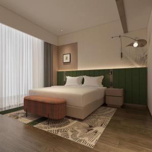 a bedroom with a large white bed with a green wall at Hilton Garden Inn Songyuan Ningjiang in Songyuan