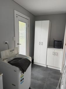a bathroom with a sink and white cabinets at Boyanup West Wing in Boyanup