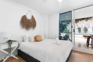 Un dormitorio blanco con una cama y una ventana grande. en Bolton - Spacious Apartment with a Beautiful Courtyard, en Newcastle