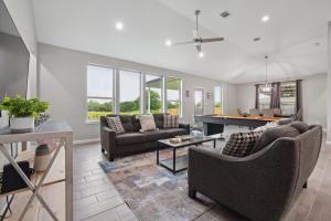 a living room with couches and a pool table at Modern Escape in Cedar Creek in Cedar Creek