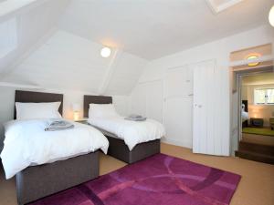 2 bedden in een kamer met een paars tapijt bij 6 Bed in Wroxham 72652 in Hoveton
