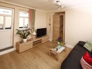 a living room with a couch and a flat screen tv at One-bedroom apartment in Bernshausen