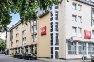 a large building with two red signs on the side of it at ibis Aachen Marschiertor - Aix-la-Chapelle in Aachen