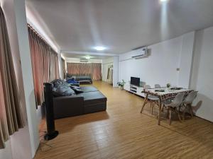 un soggiorno con un divano nero e un tavolo di Beachfront Family room, Relax & Sunbathe 5 guests a Ban Chak Phai