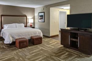 a hotel room with a bed and a flat screen tv at Hampton Inn Corinth in Corinth