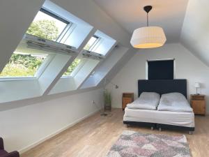 a attic room with a bed and two windows at 4 star holiday home in oxie in Oxie