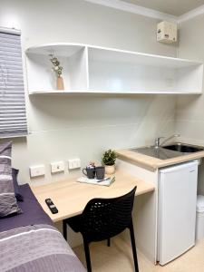 a small kitchen with a table and a sink in a room at Kalgoorlie Caravan Park in Kalgoorlie