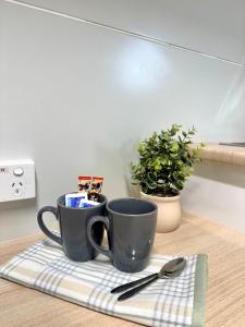 two coffee mugs sitting on a towel on a table at Kalgoorlie Caravan Park in Kalgoorlie