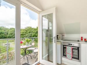 a kitchen with a sliding glass door leading to a balcony at 1 Bed in Narberth 46737 in Begelly