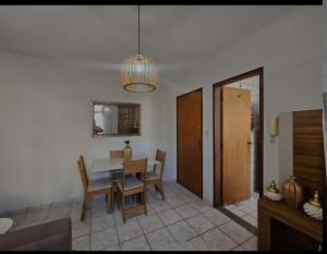 a dining room with a table and chairs and a mirror at Apartamento Praia do Morro in Guarapari