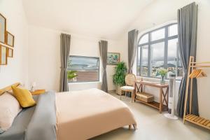 a bedroom with a bed and a desk and a window at Homey Villa in Da Lat