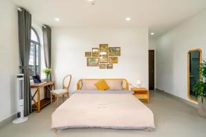 a bedroom with a bed and a desk at Homey Villa in Da Lat