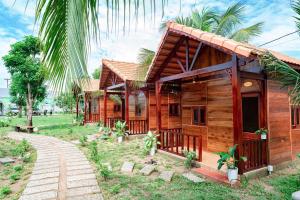 Tánh LinhHomestay 25 tháng 12 Tàpao - Đồng Kho - Tánh Linh的人行道旁有几栋木屋